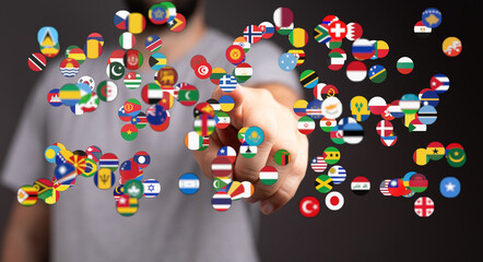 Concept image of a hand pointing at numerous country flags, representing global unity, international relations, and cultural diversity.