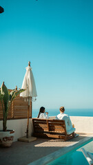 Obraz premium A couple enjoying morning coffee by the pool during their summer holiday.
