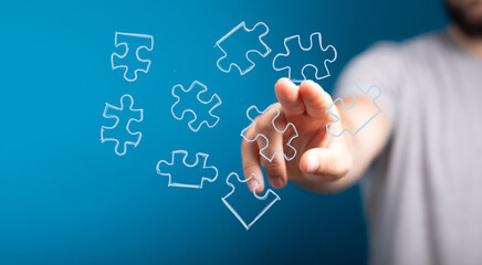 Hand reaching for puzzle pieces.  Solution, strategy, teamwork, success, connection, problem-solving, innovation, ideas.