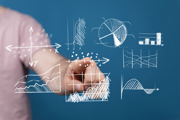 A hand pointing towards different data visualization diagrams, graphs and charts on a blue background, representing data, analysis, and business