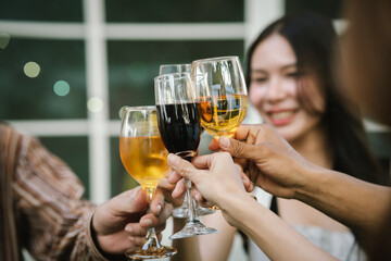 Happy young friends celebrate together at a stylish restaurant, enjoying wine, laughter, and friendship during an elegant evening gathering.	