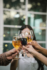 Happy young friends celebrate together at a stylish restaurant, enjoying wine, laughter, and friendship during an elegant evening gathering.	