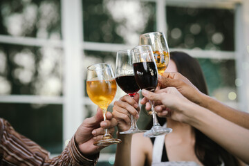 Happy young friends celebrate together at a stylish restaurant, enjoying wine, laughter, and friendship during an elegant evening gathering.	