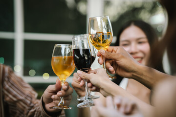 Happy young friends celebrate together at a stylish restaurant, enjoying wine, laughter, and friendship during an elegant evening gathering.	