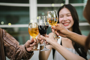 Happy young friends celebrate together at a stylish restaurant, enjoying wine, laughter, and friendship during an elegant evening gathering.	