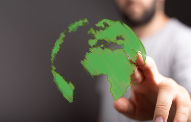 Hand interacting with a green world globe. Eco-friendly, sustainability, and global business concepts.
