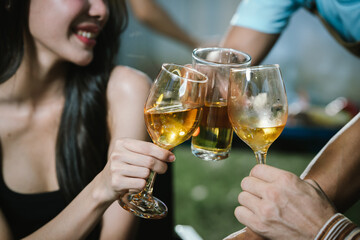 Happy young friends celebrate together at a stylish restaurant, enjoying wine, laughter, and friendship during an elegant evening gathering.	