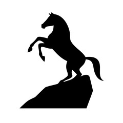 Silhouette of a horse rearing on a rocky outcrop