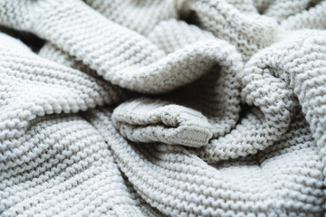 A gray blanket made of soft material is gently twisted and folded to create a cozy feel. This peaceful scene adds warmth to any living space, encouraging relaxation and comfort.