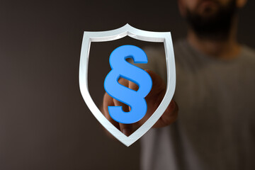Conceptual image of a shield with the paragraph symbol within it, symbolizing law, protection, and legal framework. Focus on rights, security, a