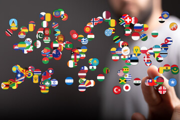 Conceptual image of a man touching a cluster of flags representing countries, emphasizing globalization and international relations. Ideal for b