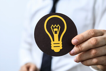 Image of a businessman holding a lightbulb symbol, representing new ideas, innovation, and solutions.