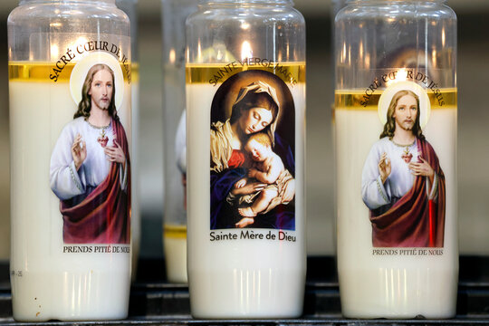 Basilica of Saint Anne of Auray. Church candles. Novenas lit with an image of Jesus. Prayer time. France.