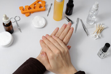 Closeup of woman hands who has nails problem. Manicure Table Nail Desk Workstation. Supplies for nails professional manicure process