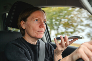 Irresponsible female driver talking on mobile phone while driving through countryside, holding...
