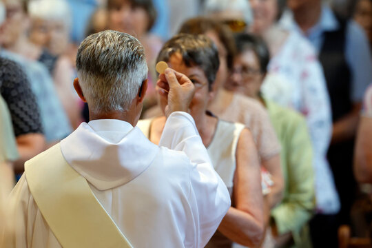 Saint Jacques church.  Deacon giving Holy Communion. Sallanches. France.