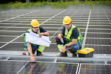 Engineers inspecting a solar panel installation, studying blueprints