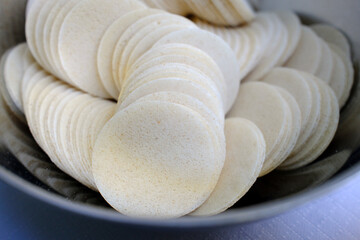 Catholic mass. Close-up of a bowl filled with round communion wafers used for Catholic Mass and Holy Communion. La Roche sur Foron.  France.