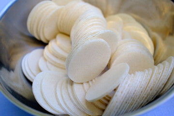 Catholic mass. Close-up of a bowl filled with round communion wafers used for Catholic Mass and...