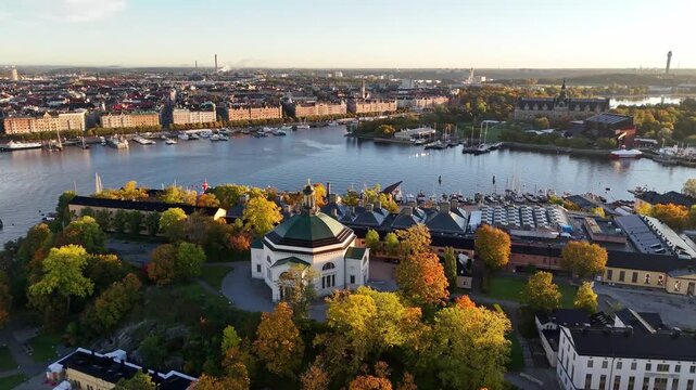 Eric Ericsonhallen and &Ouml;stermalm with Strandv&auml;gen in the background in autumn, morning warm sun, colorful trees, Stockholm, Sweden
