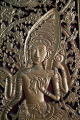 Obraz premium Wat May Souvannapoumaram temple. Door decorated with a celestial dancer. Luang Prabang. Laos.