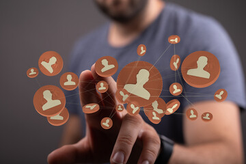 A conceptual shot of a man using a digital interface to connect with network icons, social media, and connections.