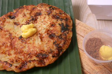 Indonesian Traditional Food Banana Pancake with Butter and Condiment On Banana Leaf