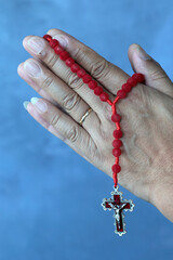Man praying the rosary.  Hail Mary, full of grace. Close-up of the crucifix.