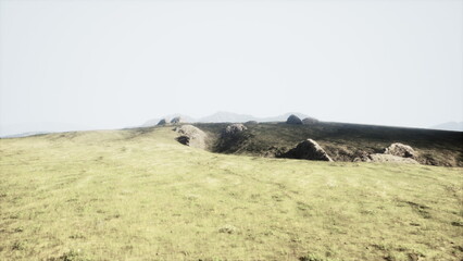 A vast landscape stretches out, showcasing green grasslands bathed in bright light. Distant rocky hills create a serene horizon, evoking a sense of peace and tranquility.