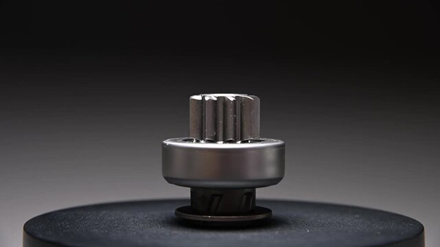 New parts are rotating. A Bendix starter gear drive for starting the engine on a gray gradient background. A classic gear drive transmits torque.
