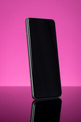 Modern Smartphone with Blank Black Screen for Mockup, Sleek Design, Reflecting on Glossy Surface. Tech Concept on Pink Background.
