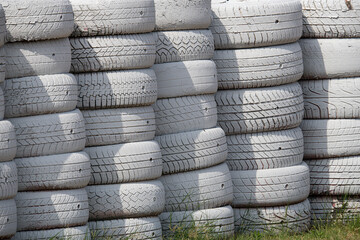 White painted old tires stacked and creating a safety barrier for a race track