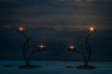 Вurning candles stands on wooden desk in the dark. Template with copy space.