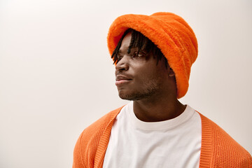 Stylish young man exudes confidence in vibrant orange attire, showcasing modern fashion trends
