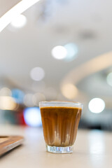 A glass of dirty latte on the table. A latte with an added shot of espresso, giving it a stronger...