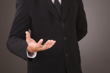 Asian Man standing and shows outstretched hand. COPY SPACE. No face.