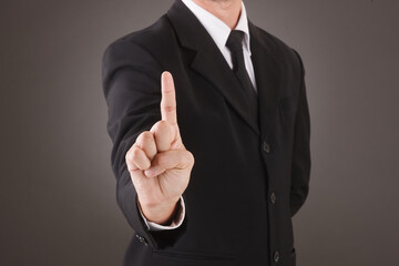 Asian Man standing and shows outstretched hand with Pointing Finger. COPY SPACE. No Face.