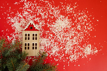 Christmas decoration with wooden house and green pine on red background