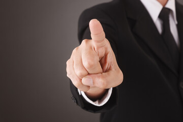 Asian Man standing and shows outstretched hand with Pointing Finger. COPY SPACE. No Face.