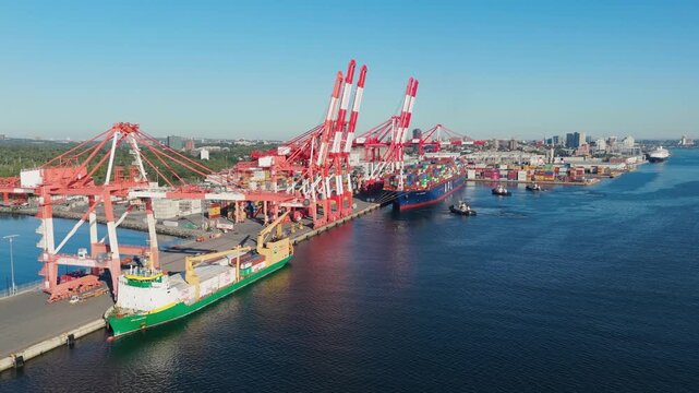Canadian Maritime Hub In Operation. Container Ship Moored In Halifax With Cranes Unloading Export Goods In Bright Daylight From Aerial Angle. Halifax Harbor Container Port And Docked Ship