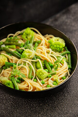 Spaghetti vegetables green peas, broccoli, string beans, kohlrabi vegetarian pasta tasty snack fresh delicious gourmet food background on the table rustic top view copy space vegan food