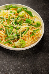 Spaghetti vegetables green peas, broccoli, string beans, kohlrabi vegetarian pasta tasty snack fresh delicious gourmet food background on the table rustic top view copy space vegan food