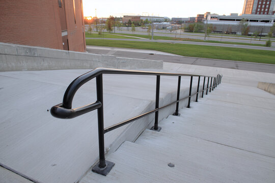 Escalera de hormig&oacute;n con barandilla met&aacute;lica negra en entorno urbano moderno, ideal para estudios de accesibilidad, dise&ntilde;o arquitect&oacute;nico y planificaci&oacute;n de espacios p&uacute;blicos en zonas residenciales