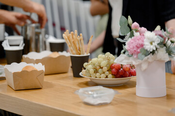 Close-up of a snack setting with red and green grapes in a business setting.