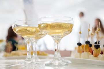 Close-up of glasses of champagne or sparkling wine and fruit canapes