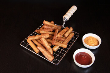 Crispy Potato Fries on Roasting Net with Mayonnaise and Ketchup in White Bowls on Dark Background — Delicious Fast Food Concept