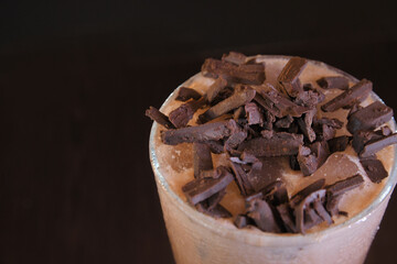 Top Angle View of Chocolate Shake Served in Large Glass with Chopped Dark Chocolate on Top in Dark Background — Delicious Dessert Beverage Concept