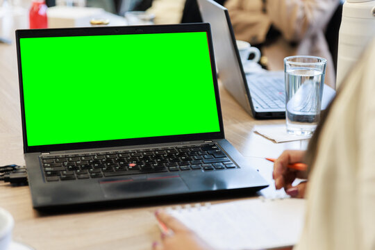 Modern Laptop with Green Screen on Office Desk Workspace