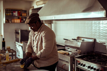 Adult chef preparing dough in kitchen