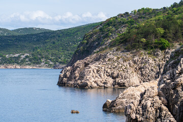 KRK Island, Vrbnik, Croatia - April 19, 2025: Cityscape. View of the coastline, rocky beach, and mountains